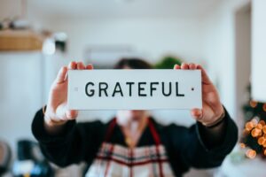 someone holding up a sign that says "Grateful"