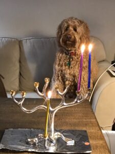Bo lighting two candles on the Hanukkiah